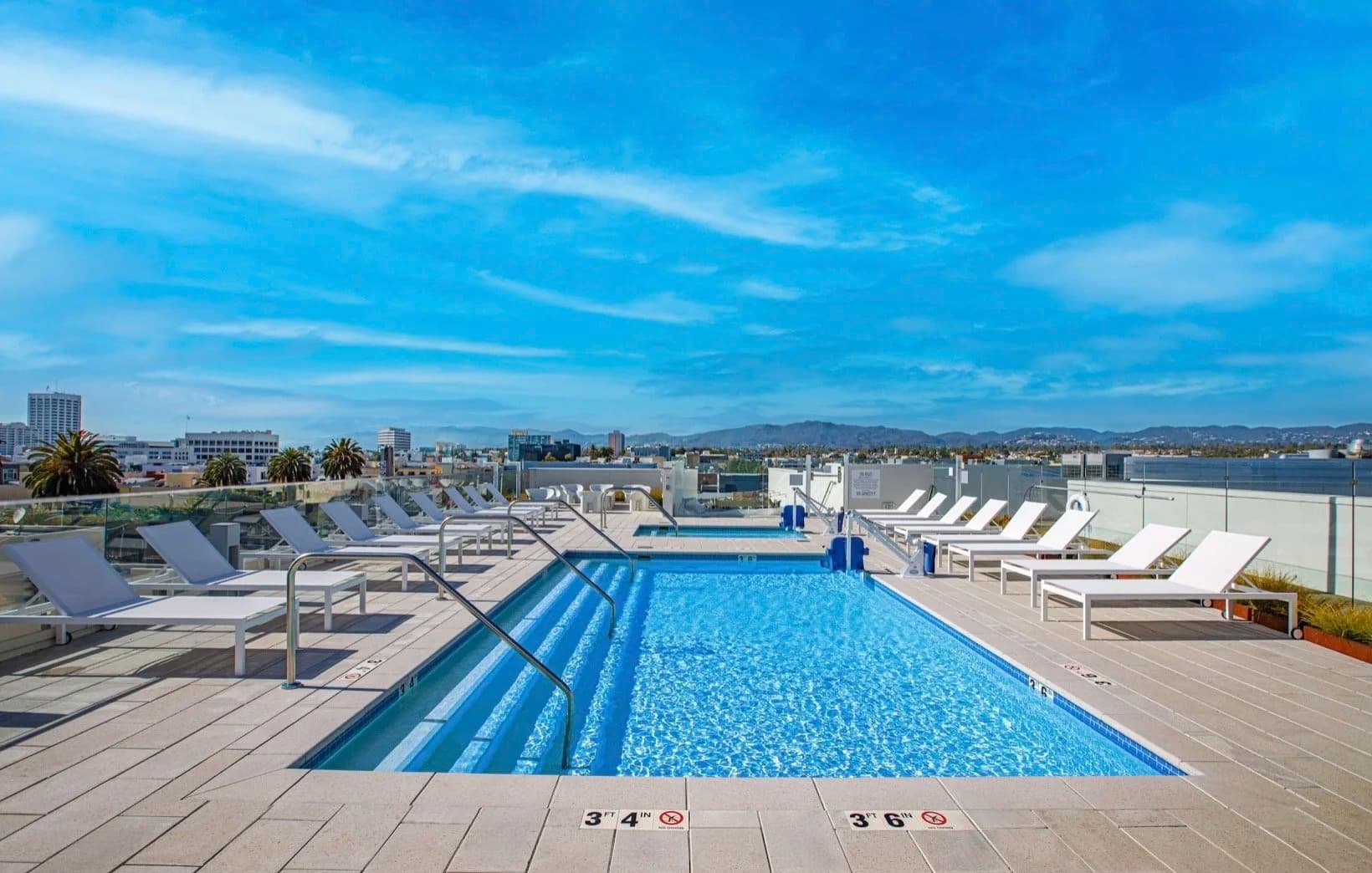 Rooftop pool with lounge chairs overlooking Santa Monica